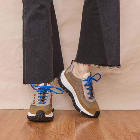 Woman wears platform leather and suede sneakers in taupe colors